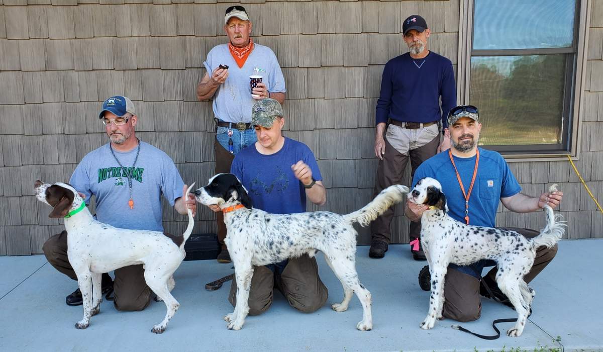 U. S. Complete Walking Puppy. From left: Huckleberry's Ring of Fire with Dean Avillion, Super Storm Atlantic with Thor Kain, and Big Run Rose with Andy Bogar. Standing: Judges David Prince and Bart Hastings