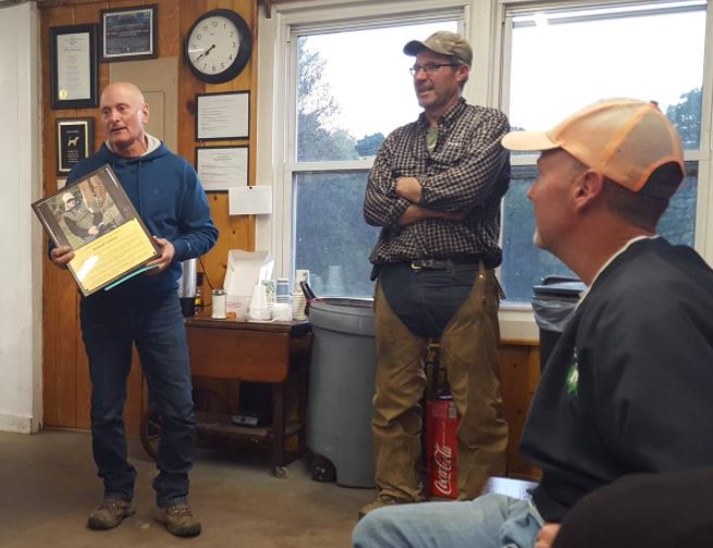 Rich Giuliano (left) acknowledges Life Patron Plaque honoring him and his contributions to field trials. At right is John Stolgitis and Bill Bonetti (seated)